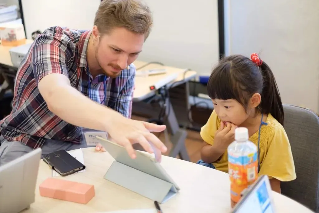 子どもにプログラミングを教えるスタッフ